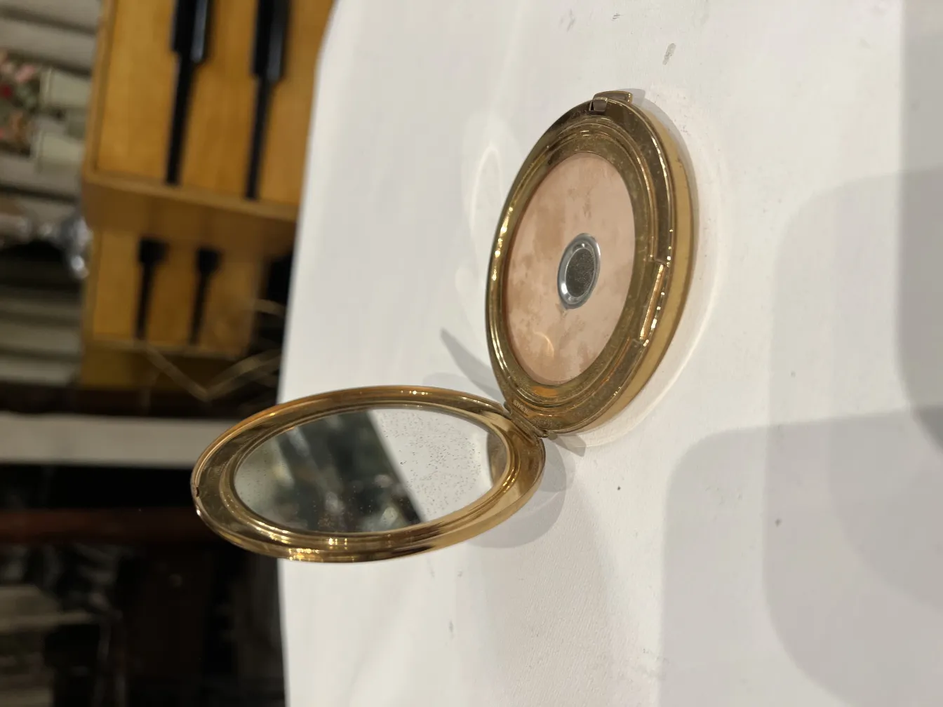 Polvera antica con specchio, elegante e pratica.