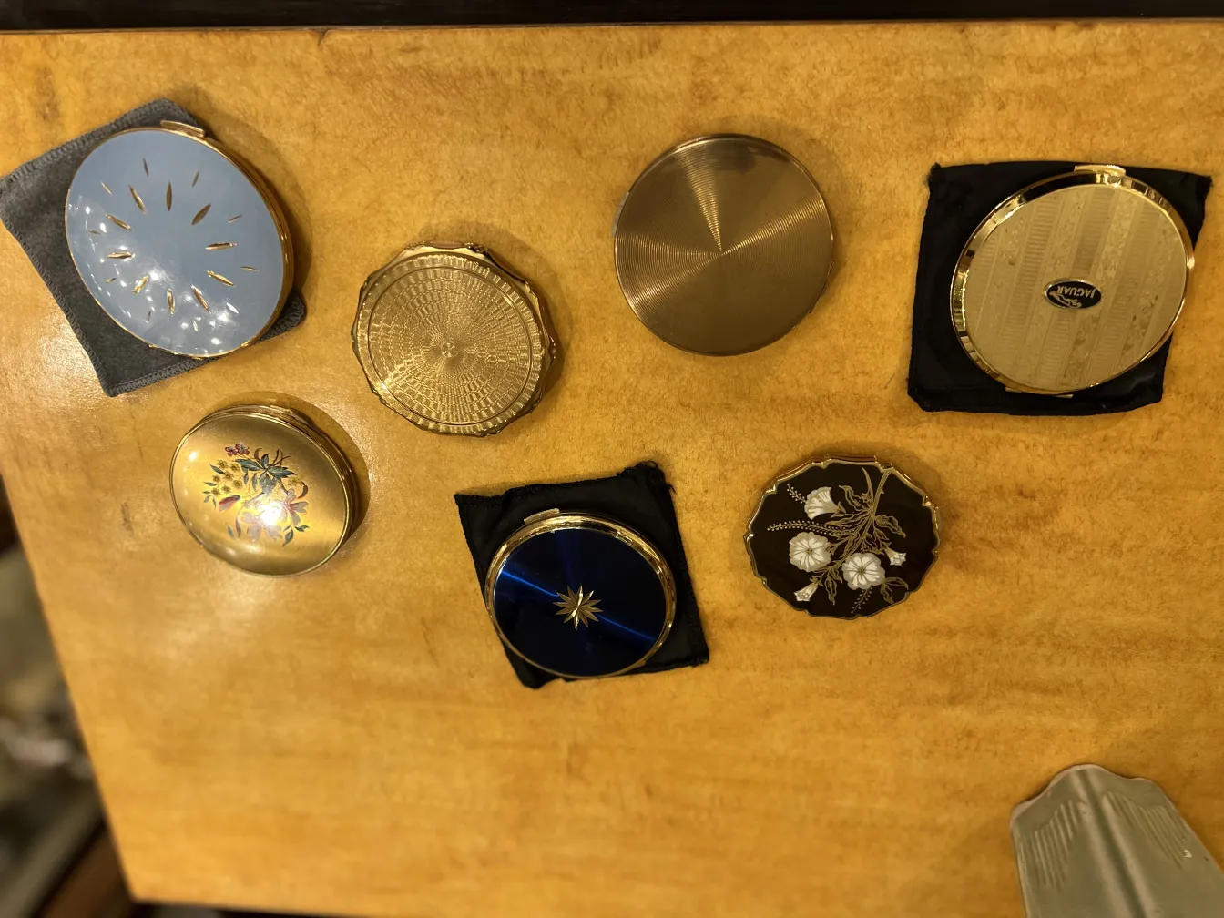 Antiker kompakt mit elegantem Design, verschiedenen Farben und Blumen, in einer sanften Umgebung.