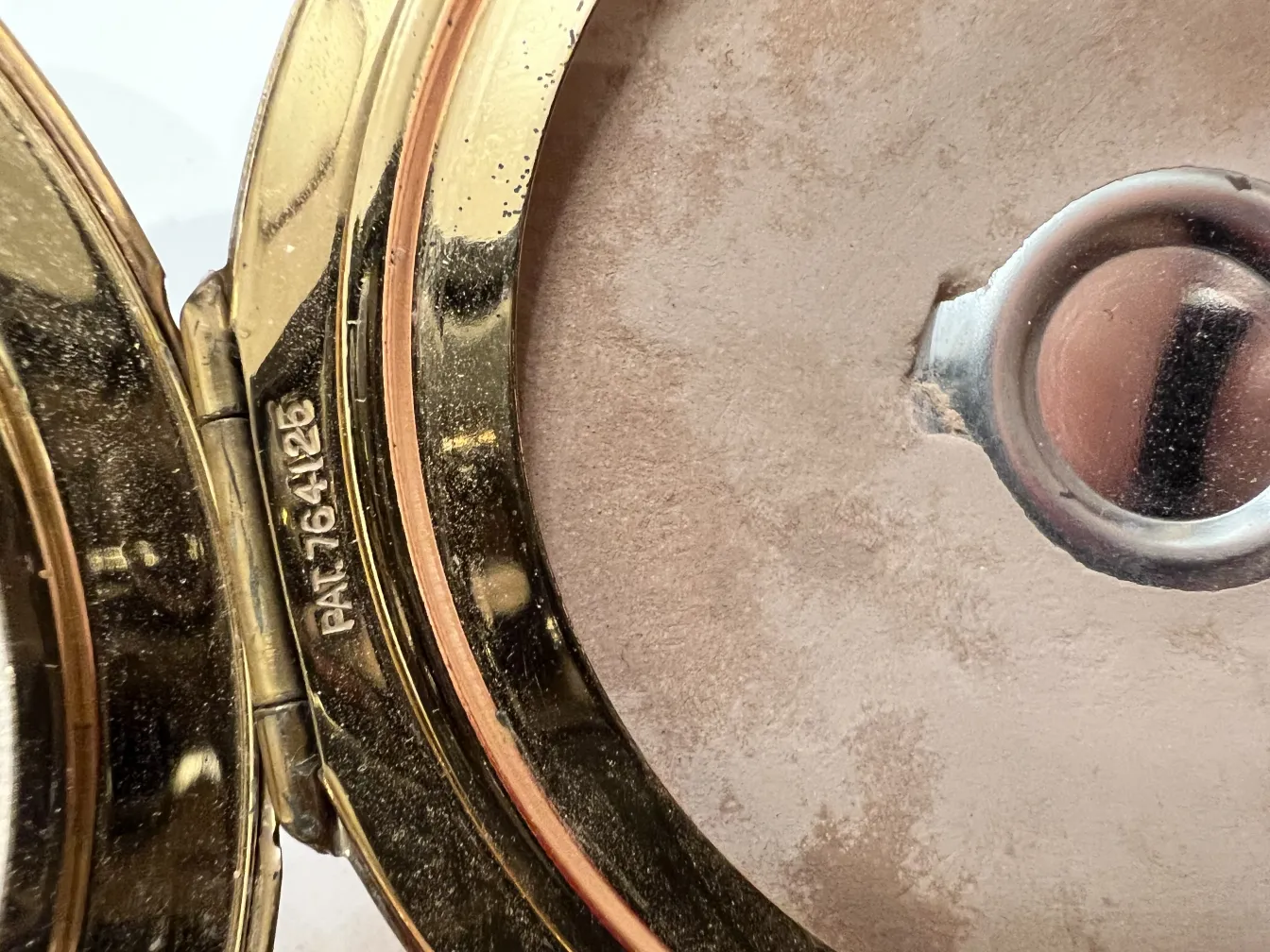 पुराना ब्लश बॉक्स, सुनहरा फिनिश और अंदर का दर्पण, भव्य माहौल।