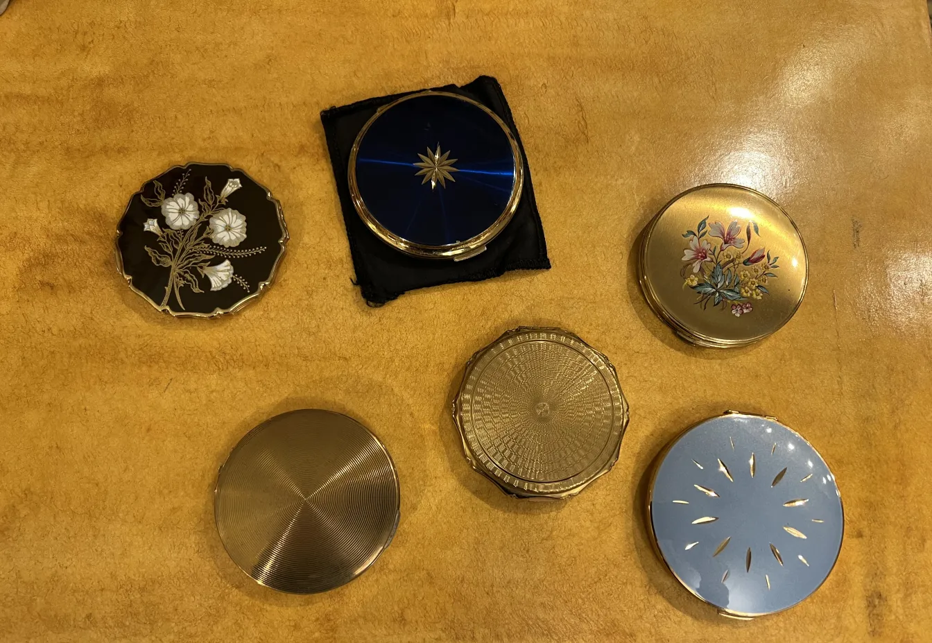 polvera antica con decorazione floreale su uno sfondo morbido