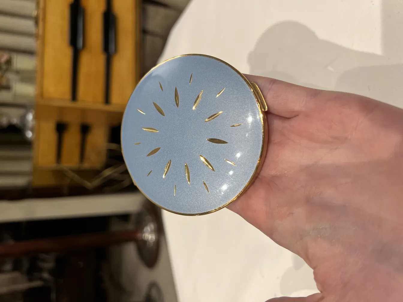 antike polvera mit goldenen Details und glänzender Oberfläche