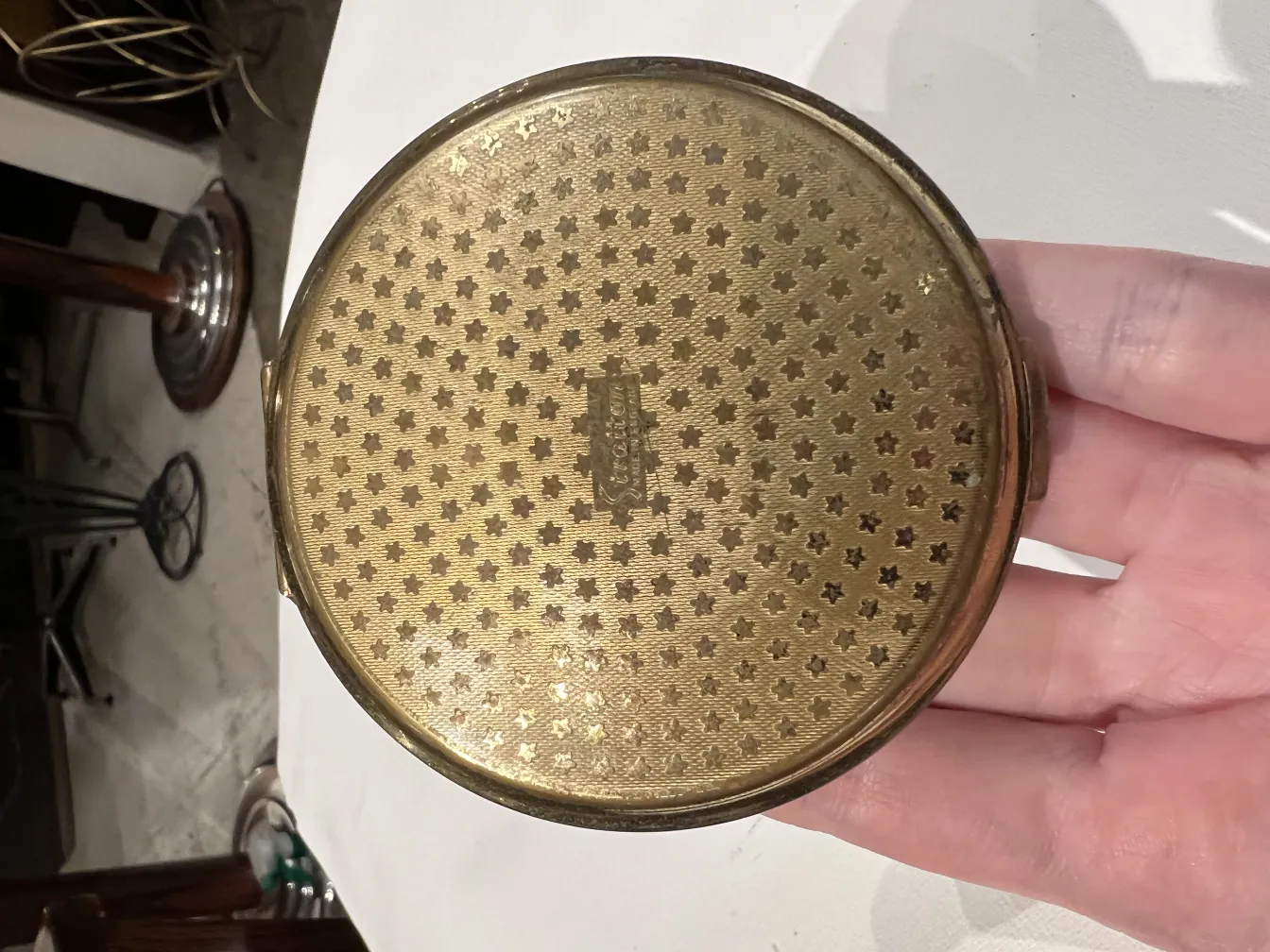 polvera antigua dorada decorada con estrellas y diseño elegante