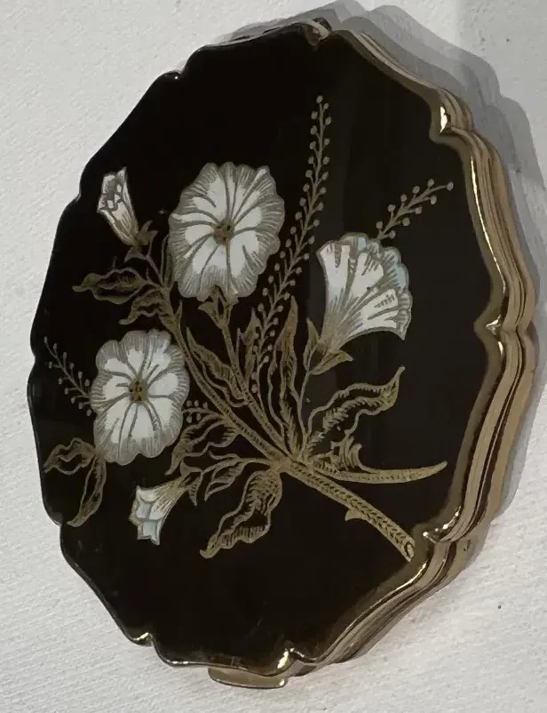 Fard Stratton England avec des fleurs blanches sur fond noir