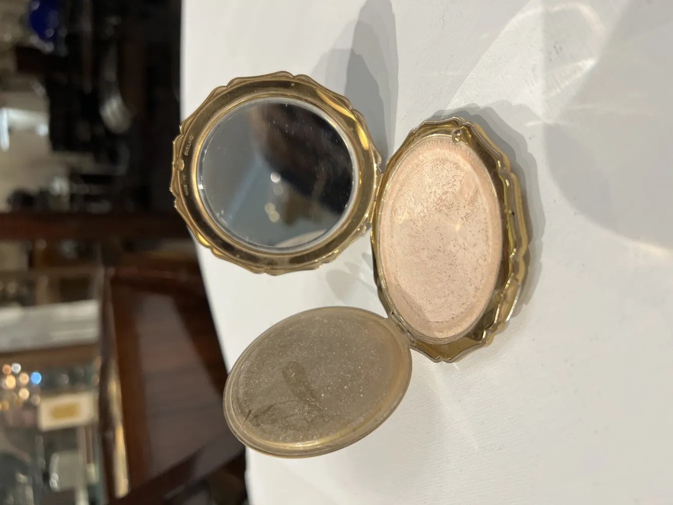 golden antique compact with mirror and blush powder, elegant design