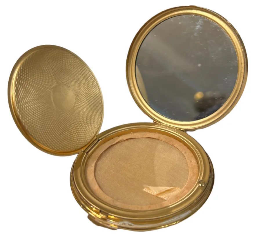 antiker kompakt mit goldenem spiegel und hellem hintergrund