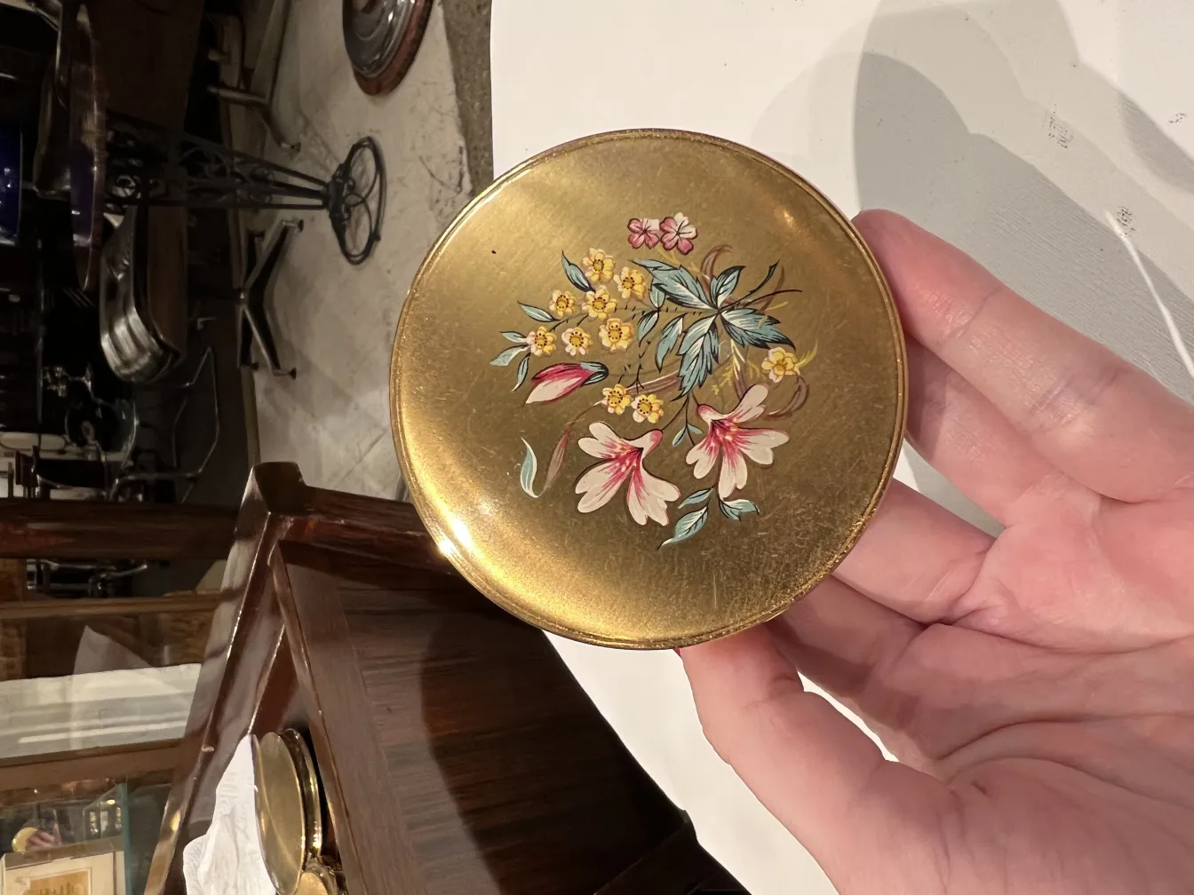 antique compact with floral decoration on top, colorful details