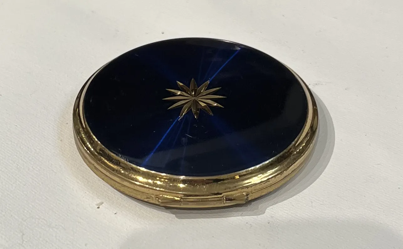 polvera ancienne avec couvercle bleu et motif floral doré