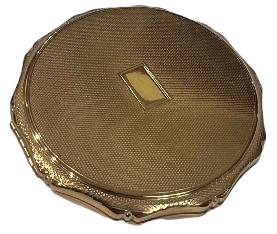 Antique golden compact with elegant details.