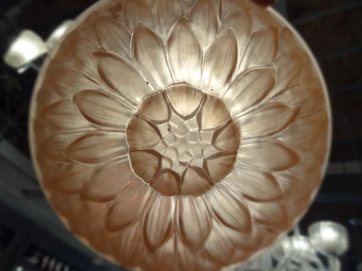 Plafonnier ancien avec motif floral en relief, ambiance chaleureuse.