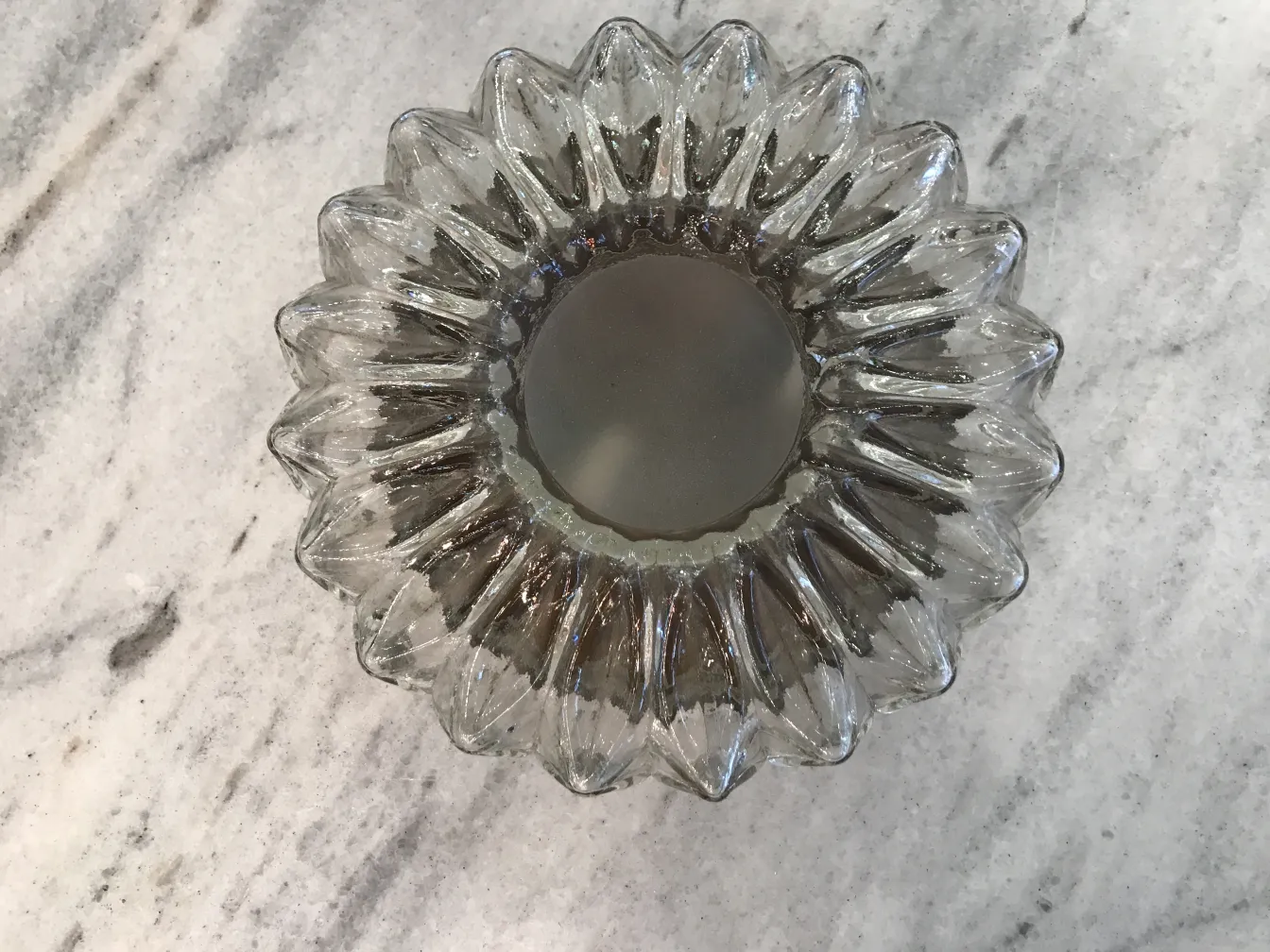 antike Deckenleuchte in Blumenform mit glänzender Oberfläche in neutralem Umfeld