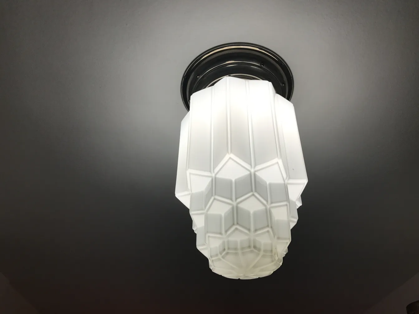 Due plafoniere antiche con design decorativo cubico, installate su un soffitto scuro.