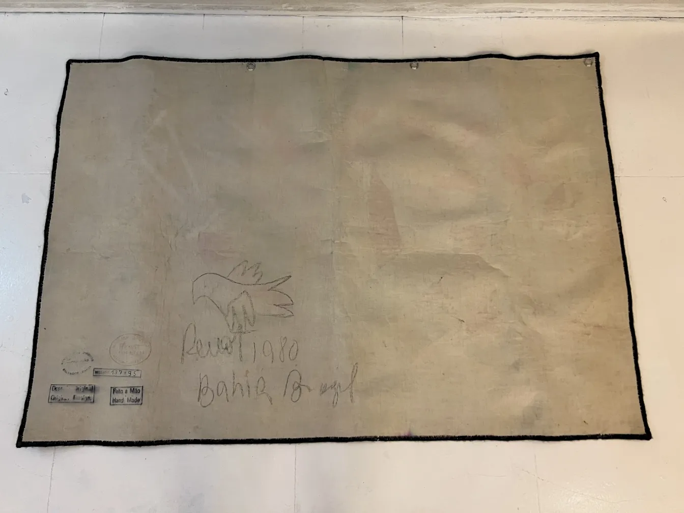 tapiz antiguo con bordado de ave sobre fondo claro