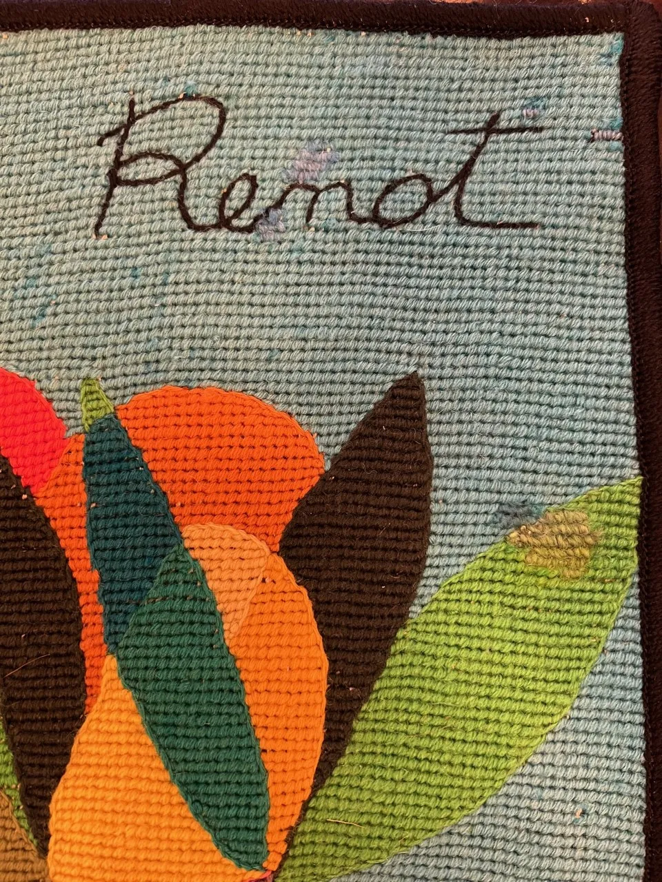 antique tapestry featuring bright flowers in various colors on a blue background