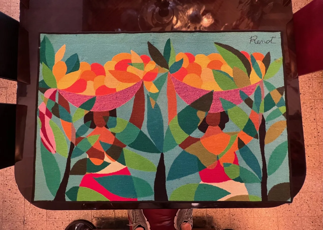 antiker Wandteppich mit leuchtenden Farben und floralem Design auf blauem Hintergrund