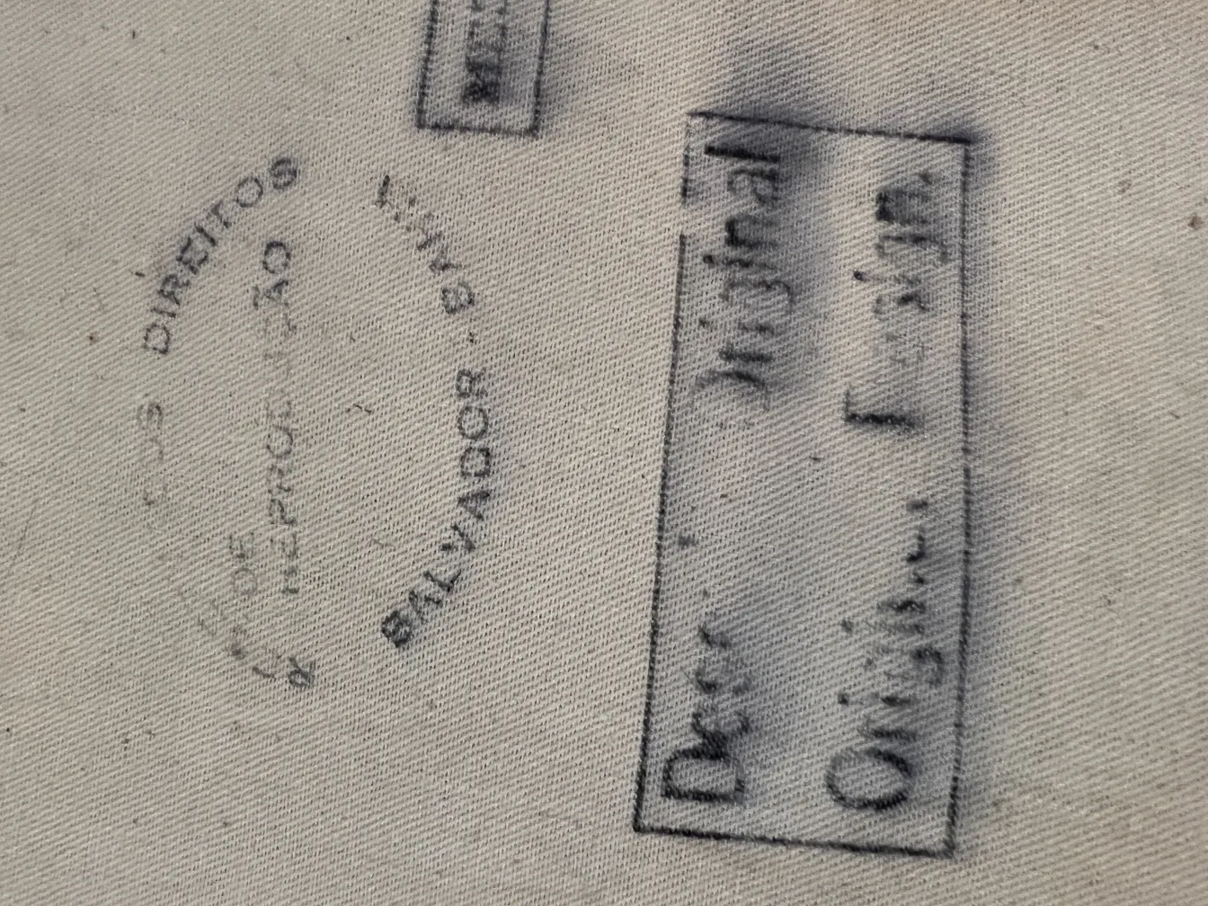 antiker Wandteppich mit Text und dunklen Details. Rustikale Umgebung.