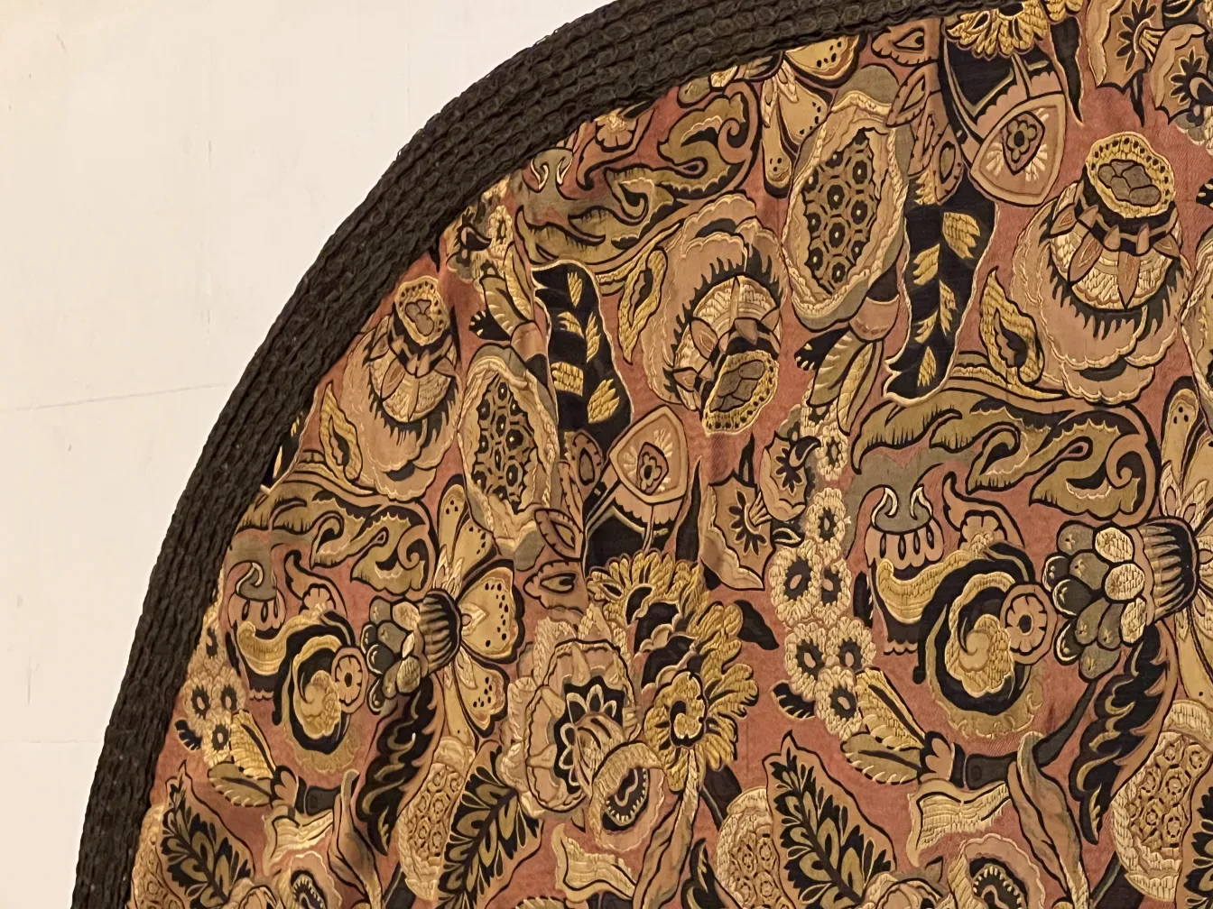 toalha de mesa antiga com padrão floral em tons quentes