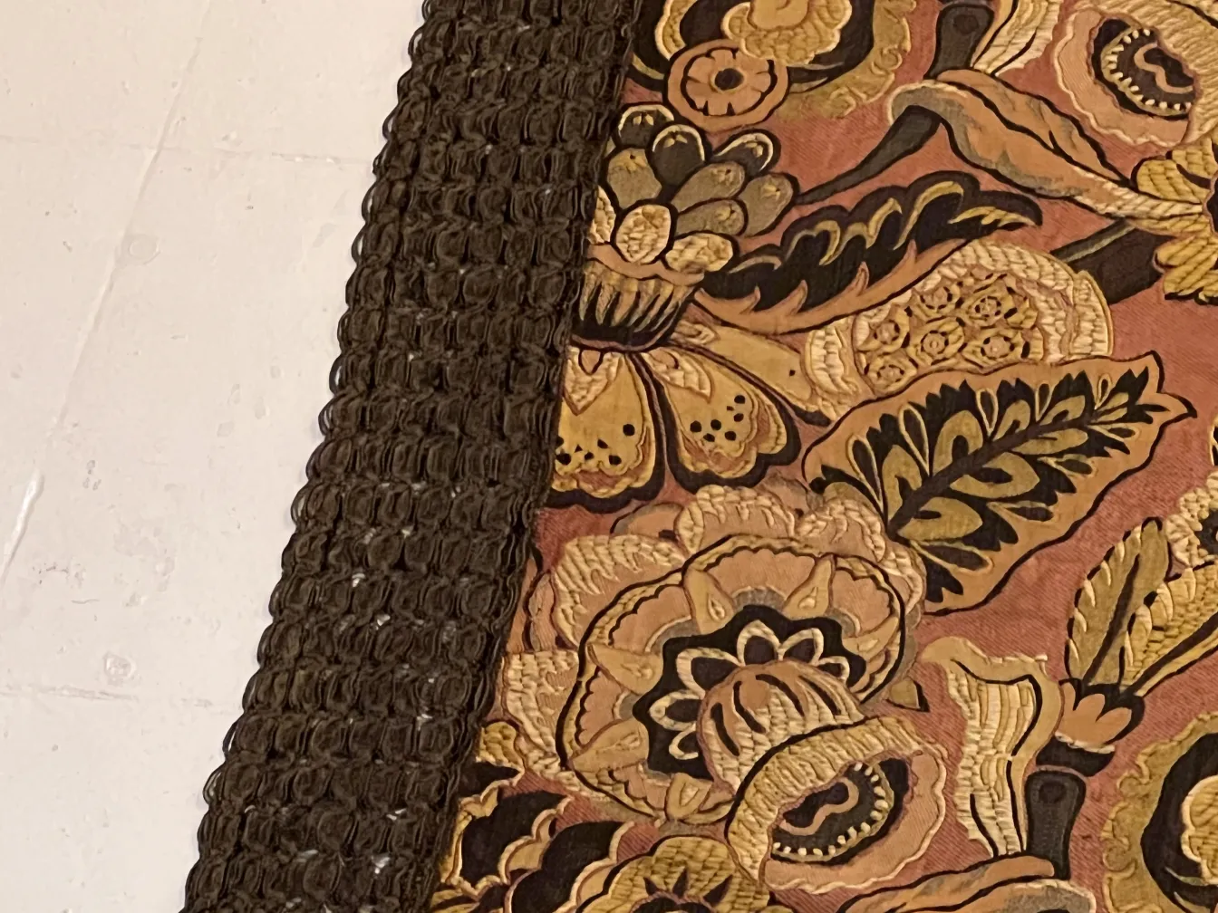 Alte Tischdecke mit floralem Design und dekorativem Rand