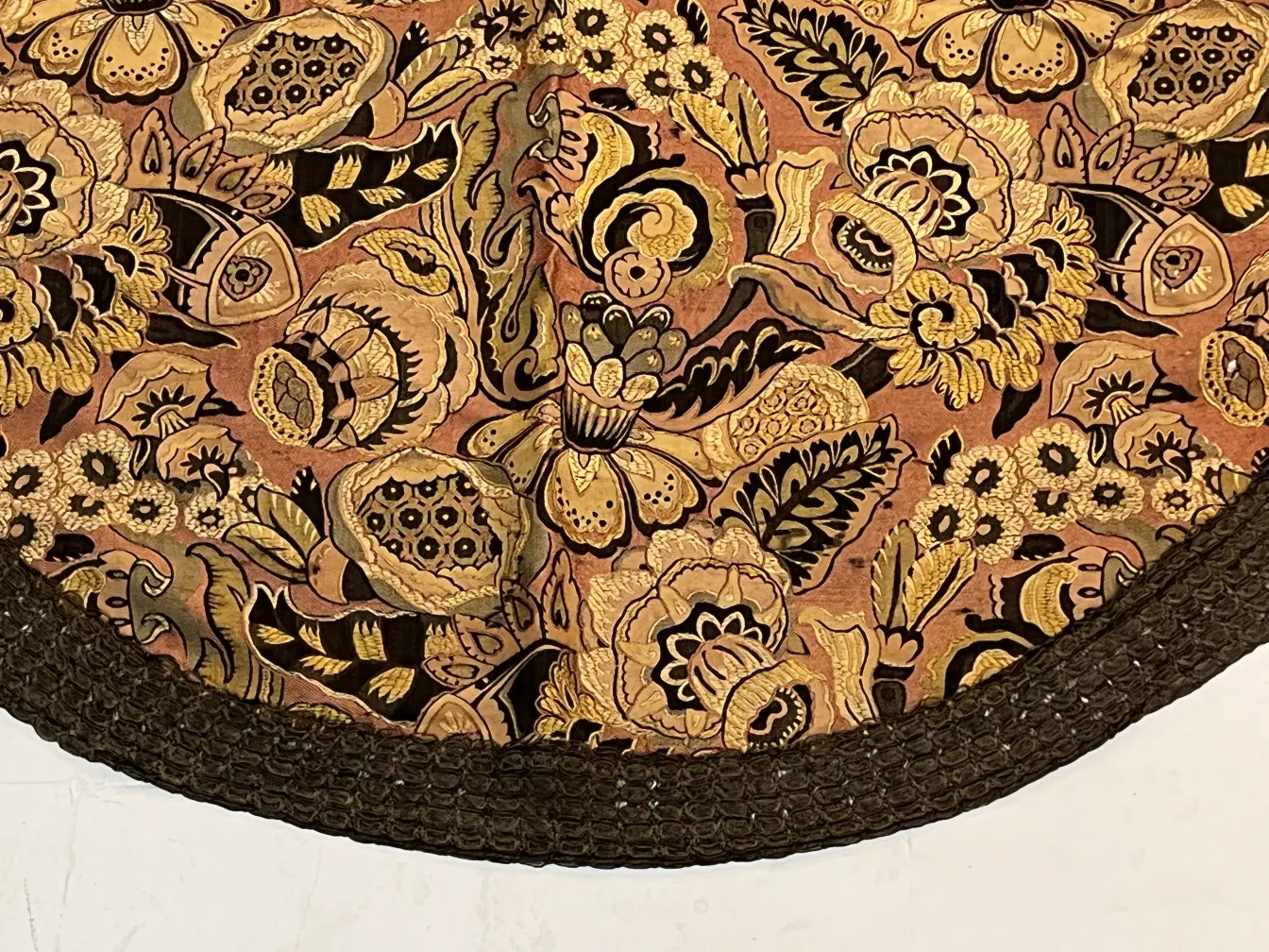 toalha de mesa antiga com padrão floral em tons quentes