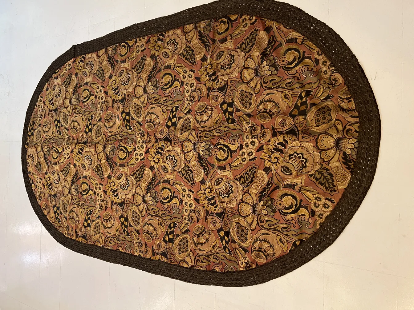 antike Tischdecke mit buntem floralem Muster auf hellem Hintergrund