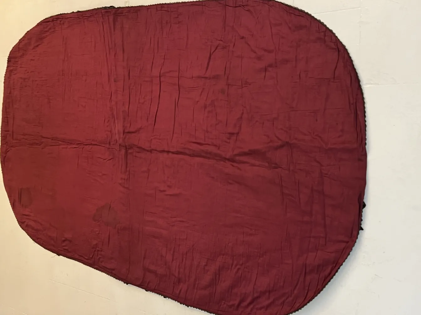 rote ovale Tischdecke mit sichtbaren Falten und Textur