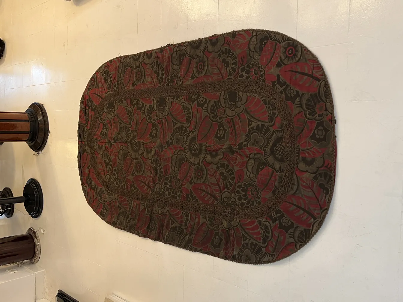 Antique tablecloth featuring red and green floral design in a classic setting