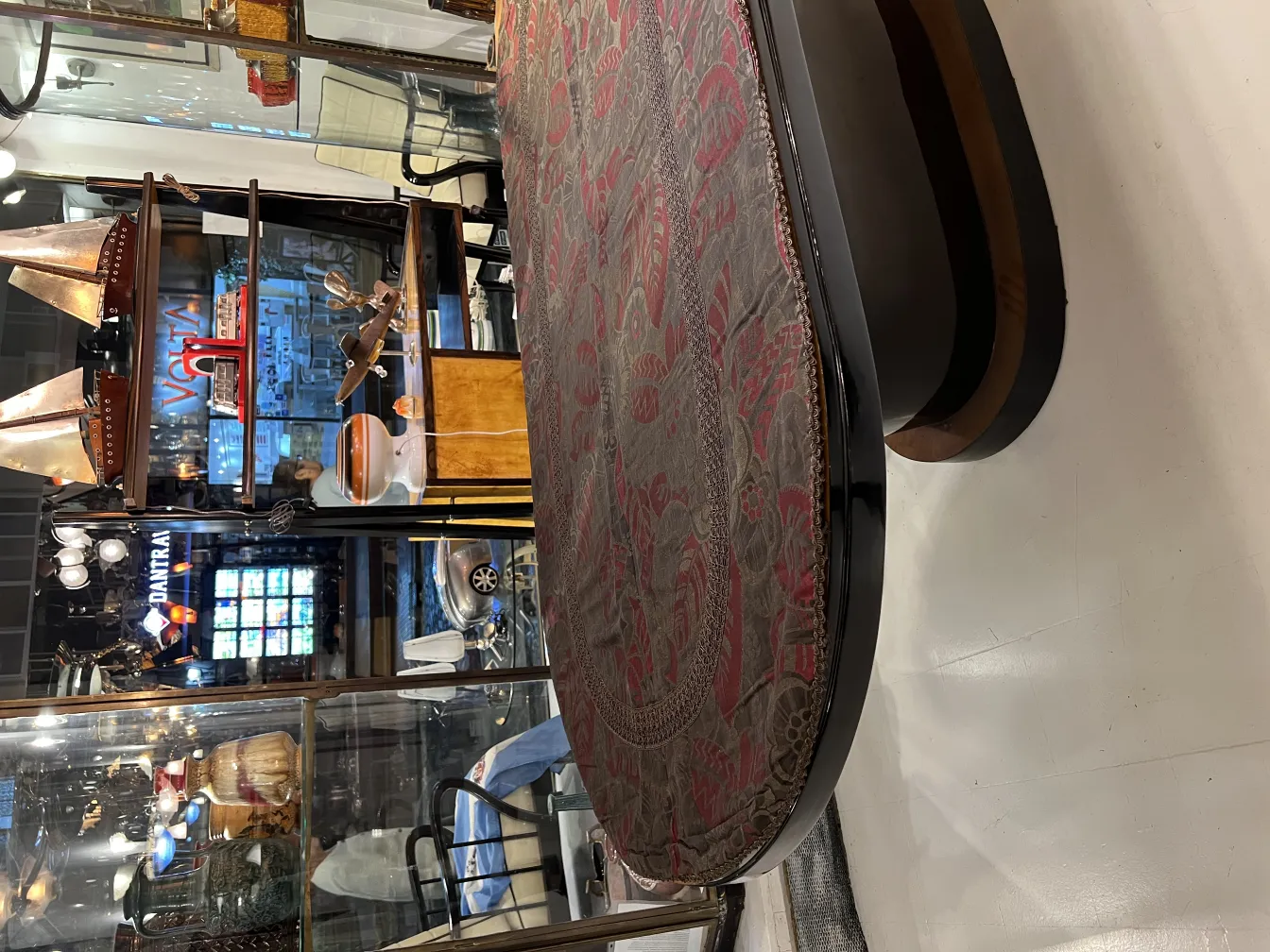 पुरानी मेज़पोश जिसमें गहरे रंग का पुष्प पैटर्न है, एक प्राचीन सेटिंग में