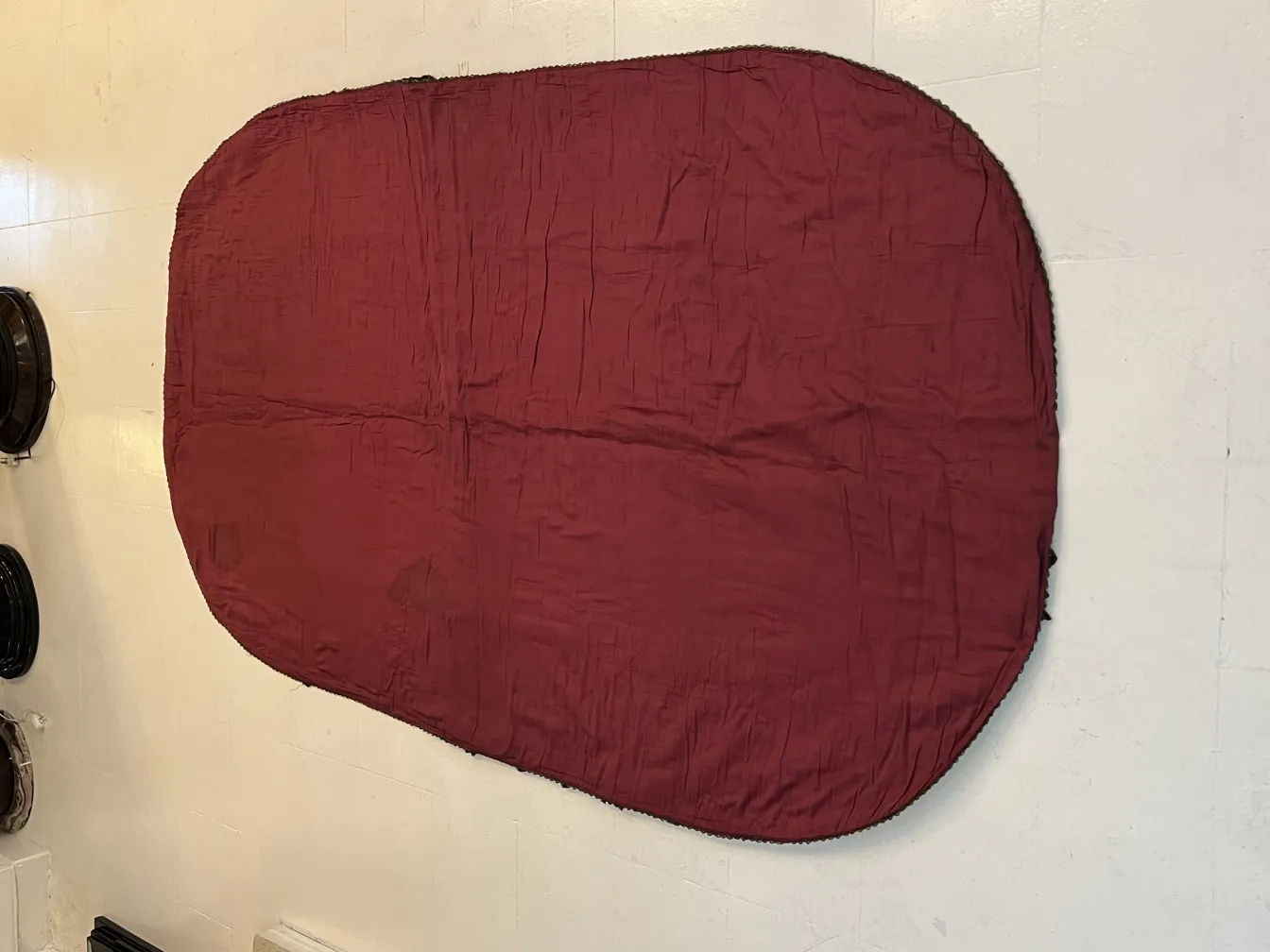 toalha de mesa antiga oval de cor bordô em fundo neutro