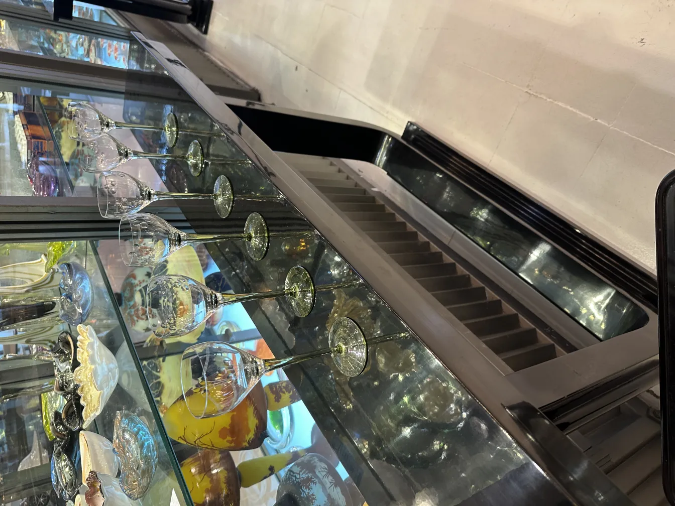 छह प्राचीन गिलास जो कांच की शेल्फ पर हैं