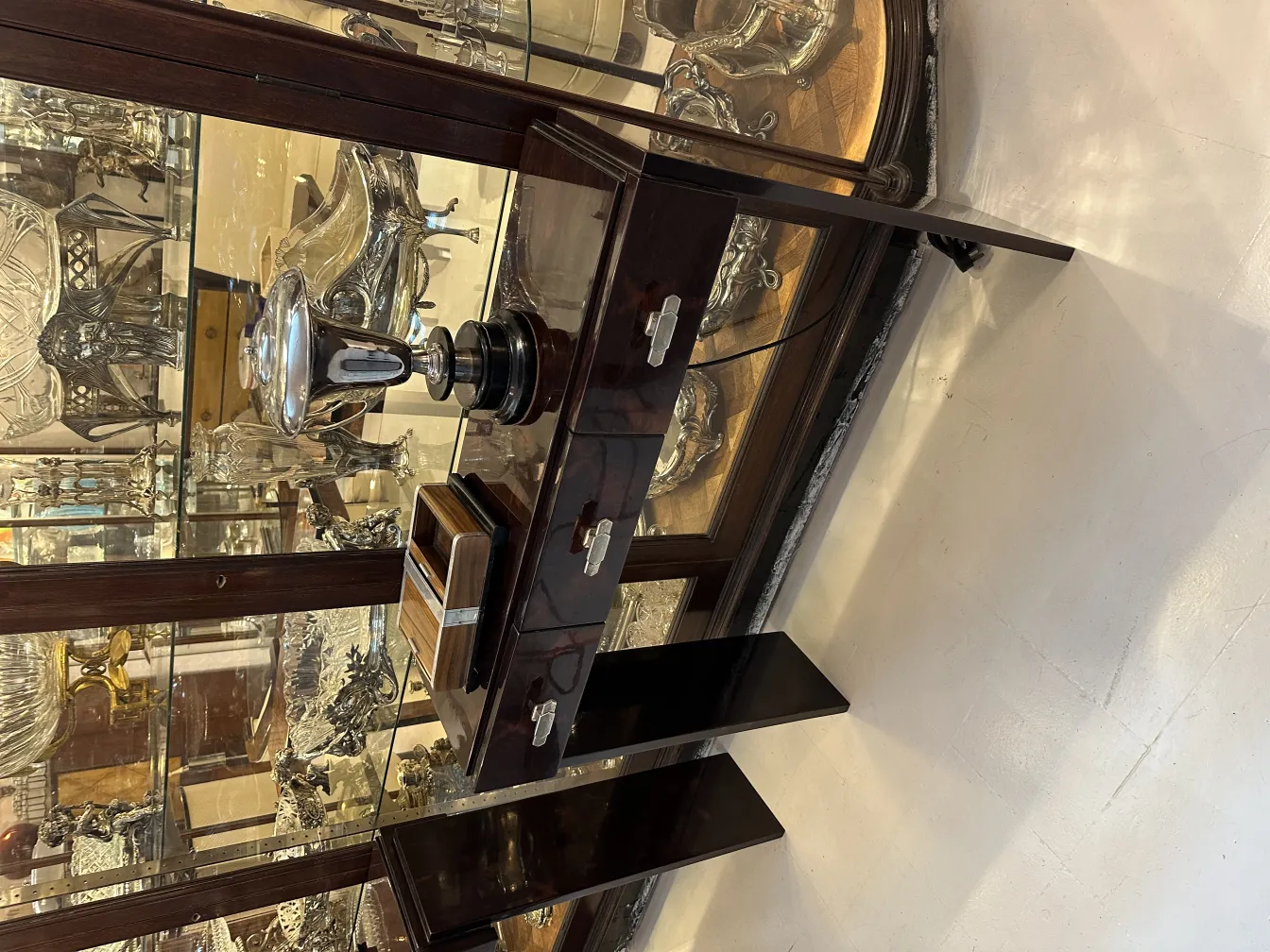 caixa antiga com detalhes decorativos, exibida em vitrine