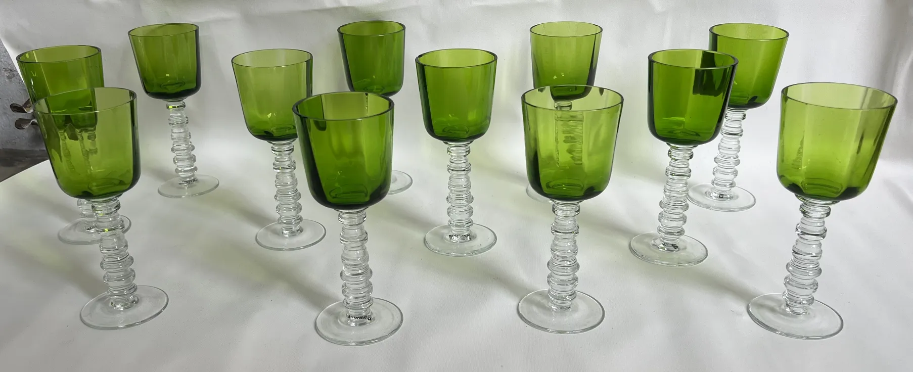 Twelve antique green glasses with elegant bases