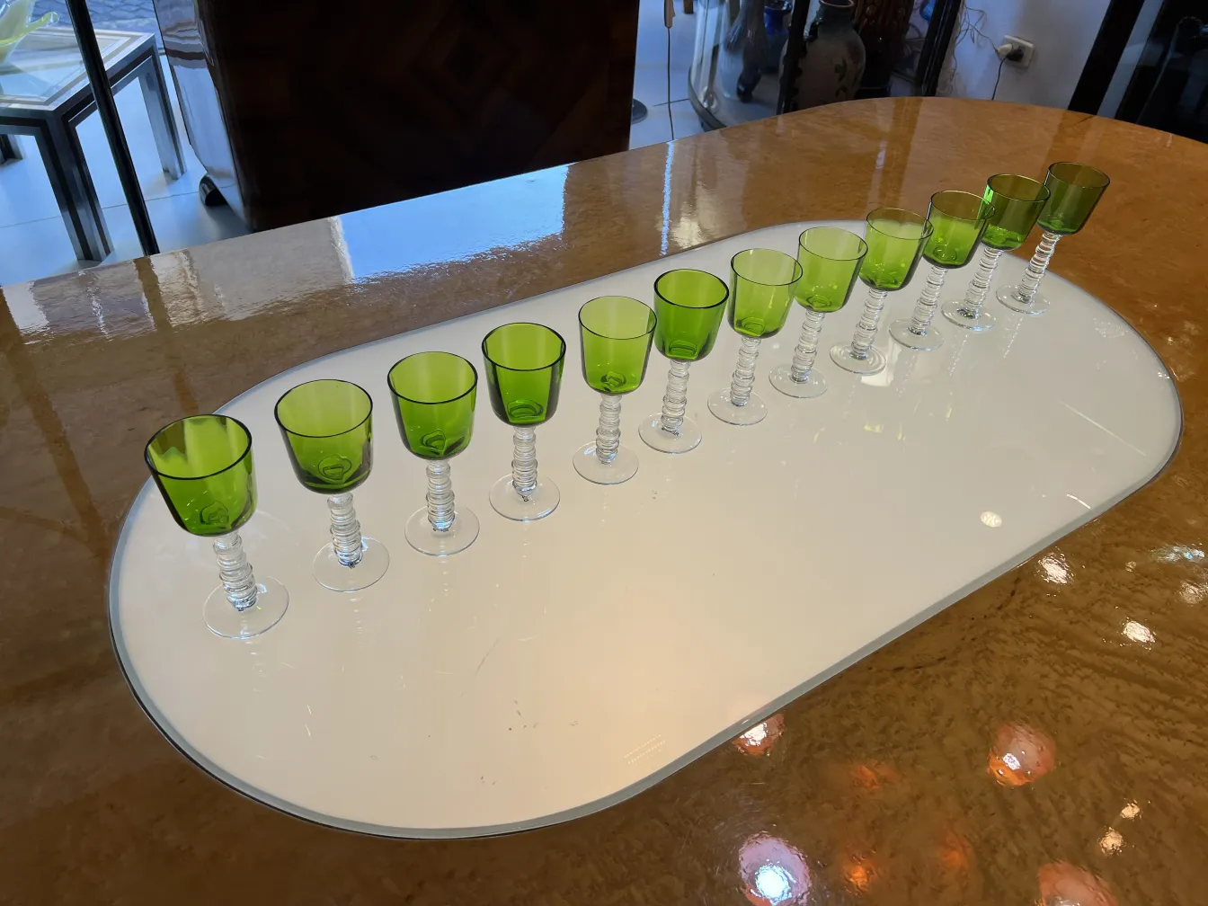 Conjunto de 12 copas Querandi antiguas de color verde brillante, dispuestas en una mesa.