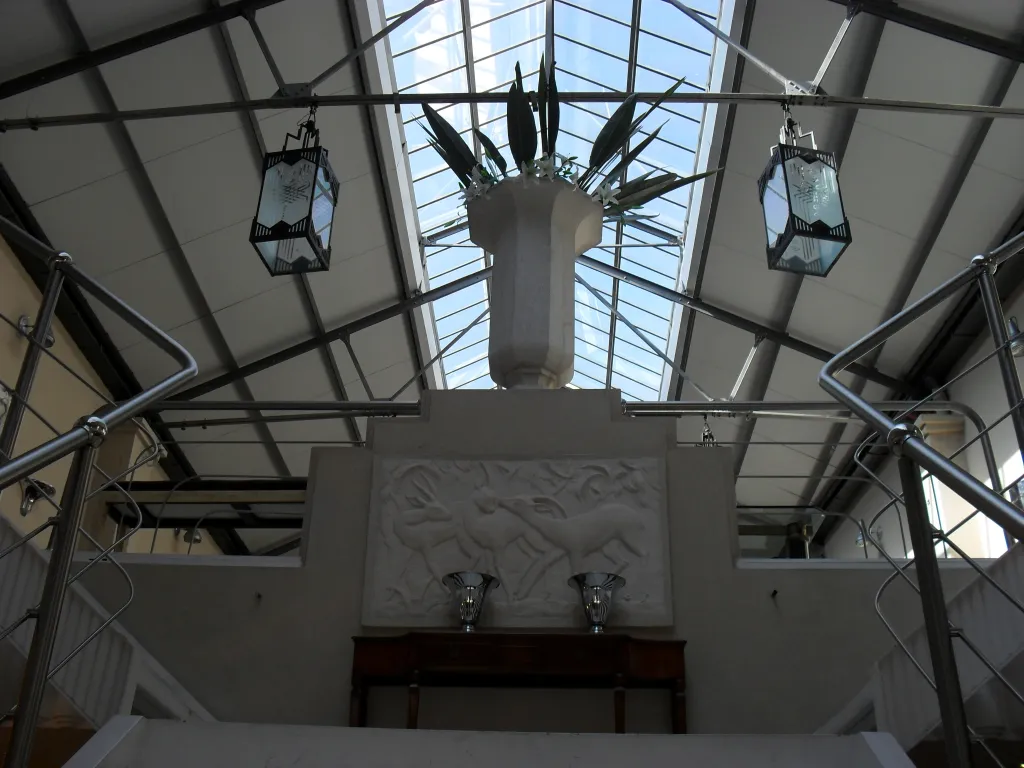 Antiguo copón decorativo en un ambiente elegante con luces y plantas