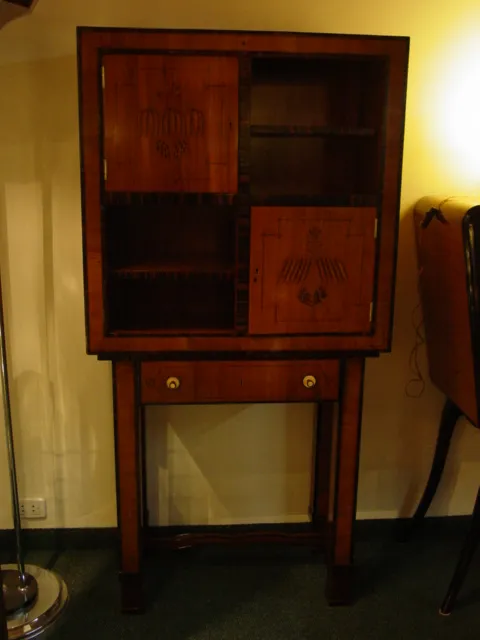 Antique cigar humidor featuring decorative details and a drawer