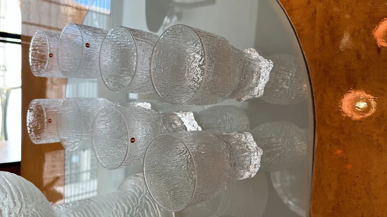 8 vasos de cristal tapio wirkkala con diseño texturizado en mesa de madera