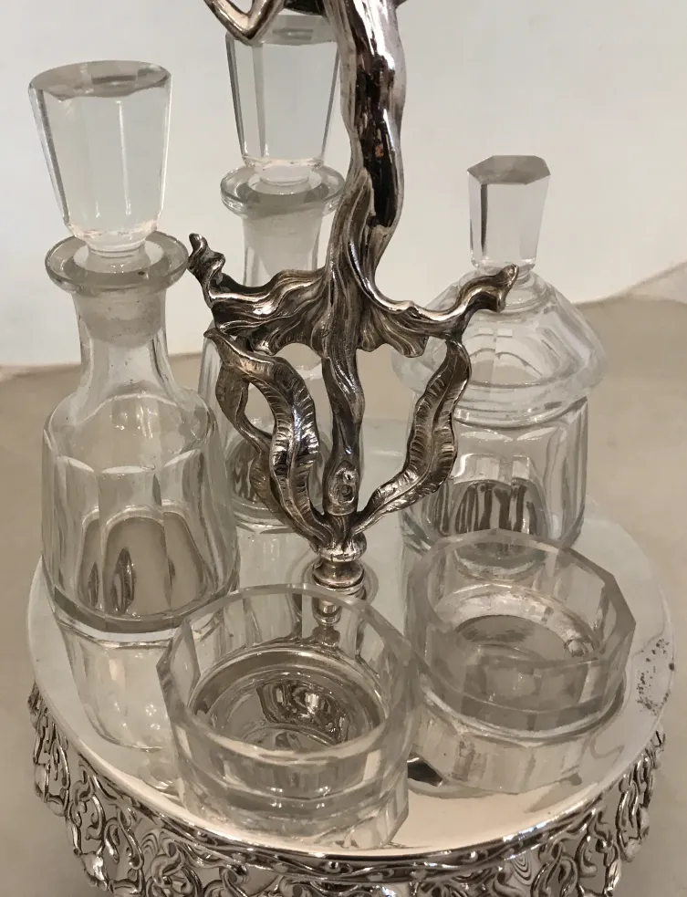 Jogo antigo de saleiro e pimenteiro com suporte decorativo.