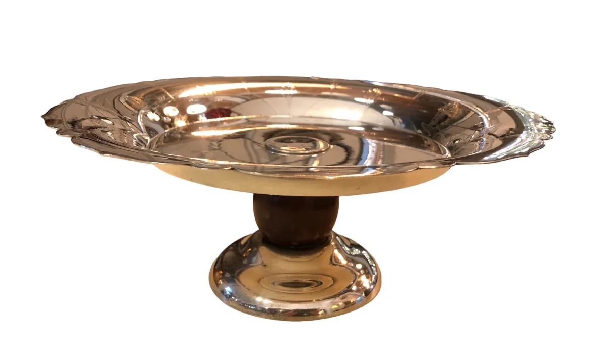 Antique pastry plate with shiny pedestal and decorative rim.