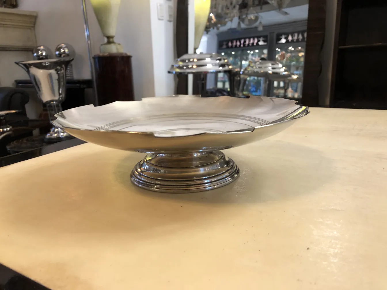 Antique pastry plate with round base and decorative edges, in an elegant setting.