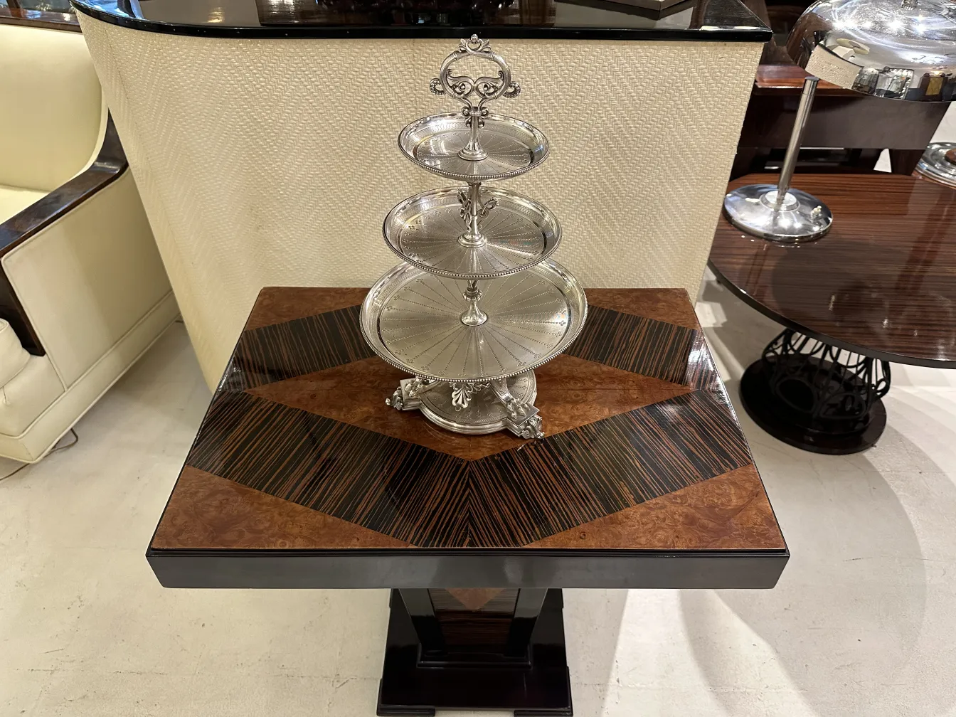 Prato de massas antigo de três níveis exibido em uma mesa.