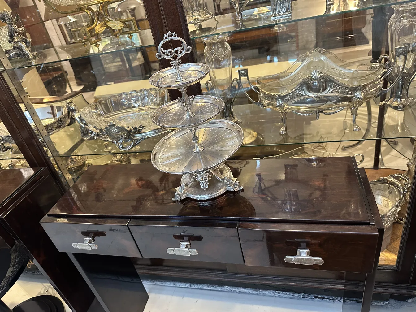 Antique pastry plate with multiple tiers, decorative, amidst a collection of antiques.