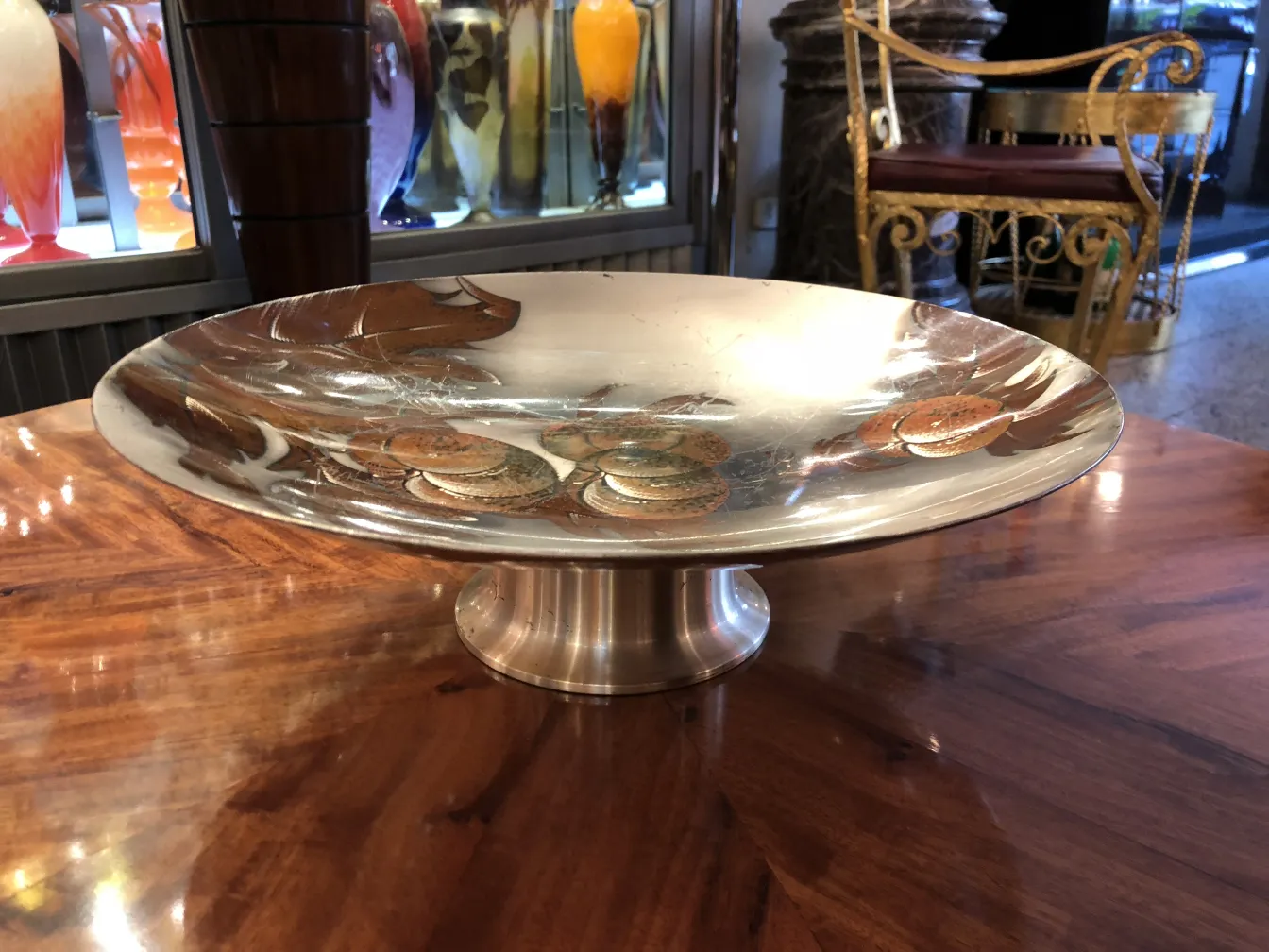 Plato de masas antiguo con diseño elegante y acabado brillante sobre una mesa de madera