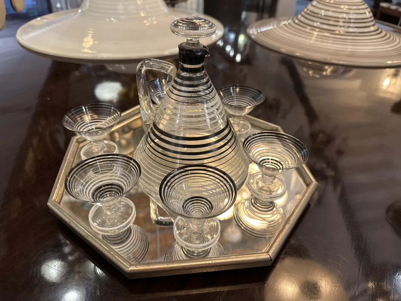 antique liqueur pitcher with decorative glasses on mirror