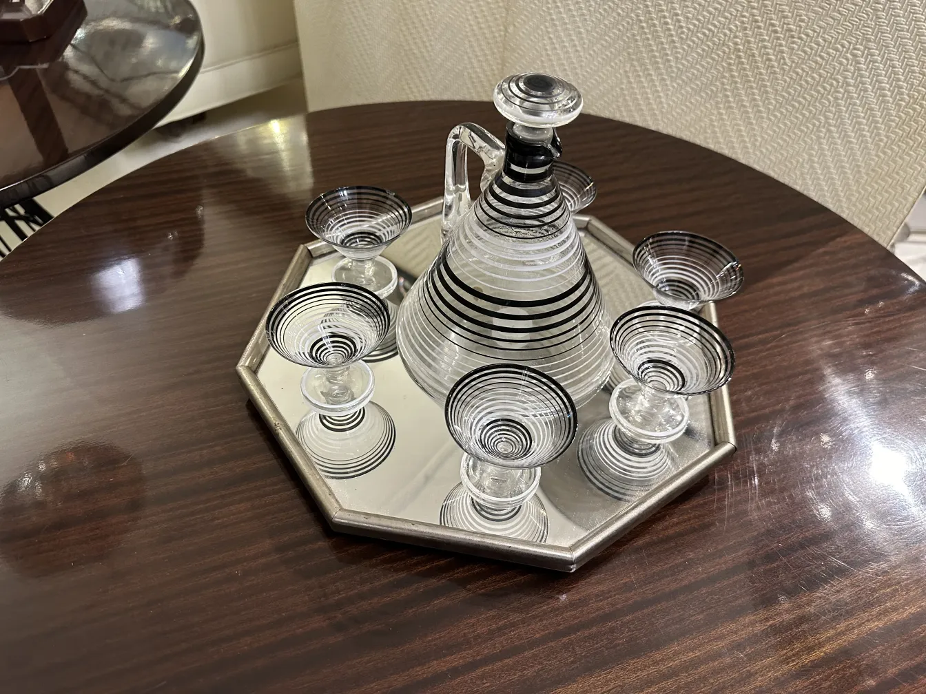 Licorera antigua con 6 copas en un ambiente elegante