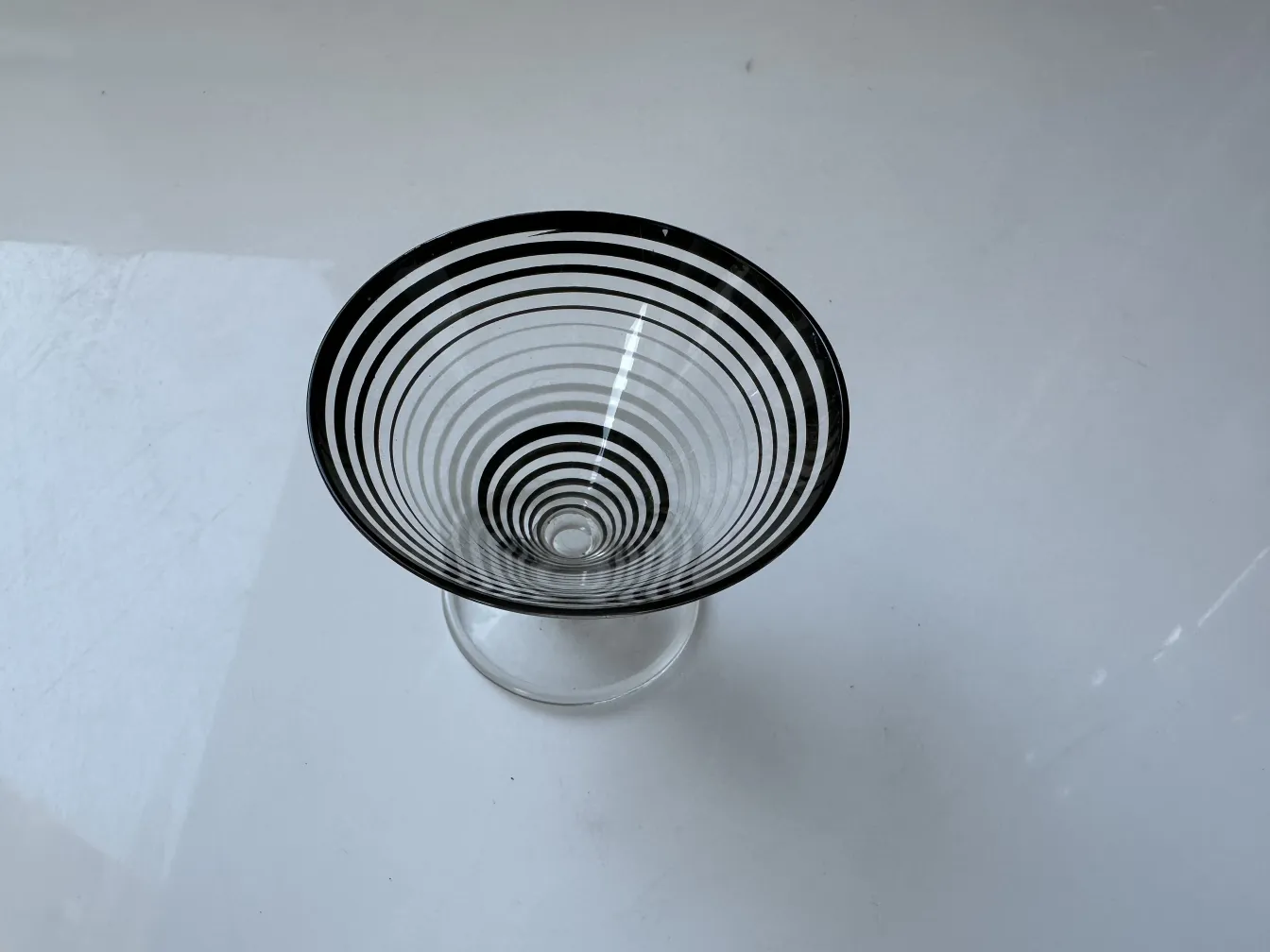 carafe à liqueur ancienne avec six verres à design spiralé, élégante et décorative sur un fond clair