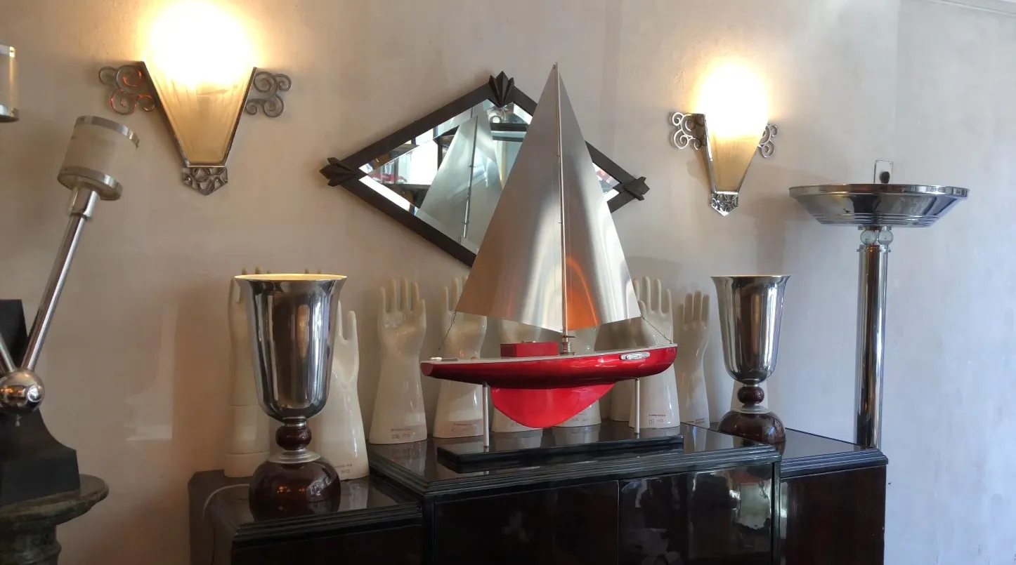 Schiff des Designers mit silbernen und roten Segeln in einer dekorativen Vitrine