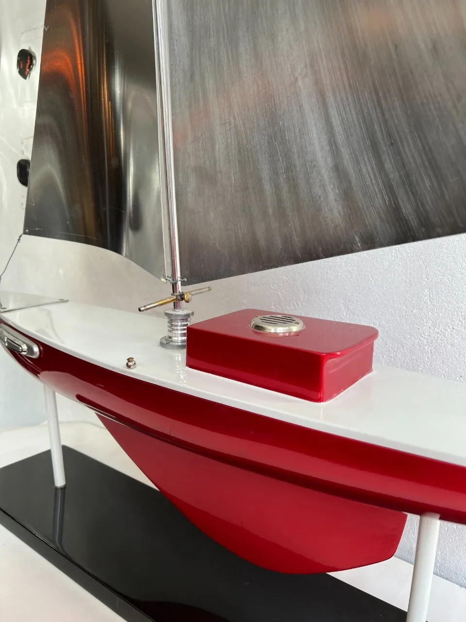 Barca antica del designer Marcelo Peña, con vela argentata e base nera, dettagli squisiti.