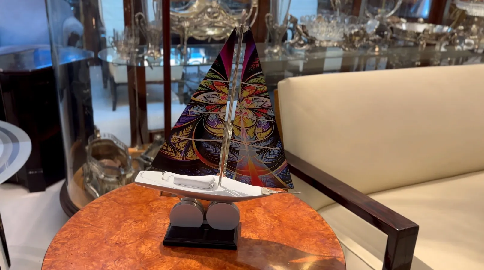 Antique designer's ship with colorful sails, elegant setting.