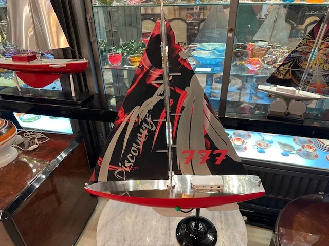 Antique designer's ship with red and black sails, details in an antique environment.