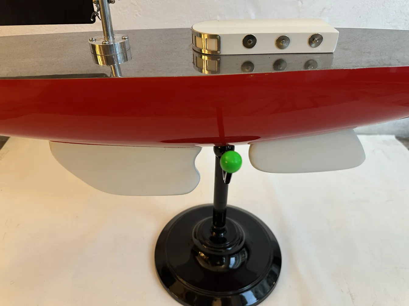 Antique designer's ship by Marcelo Peña, red color with black base and gray details.