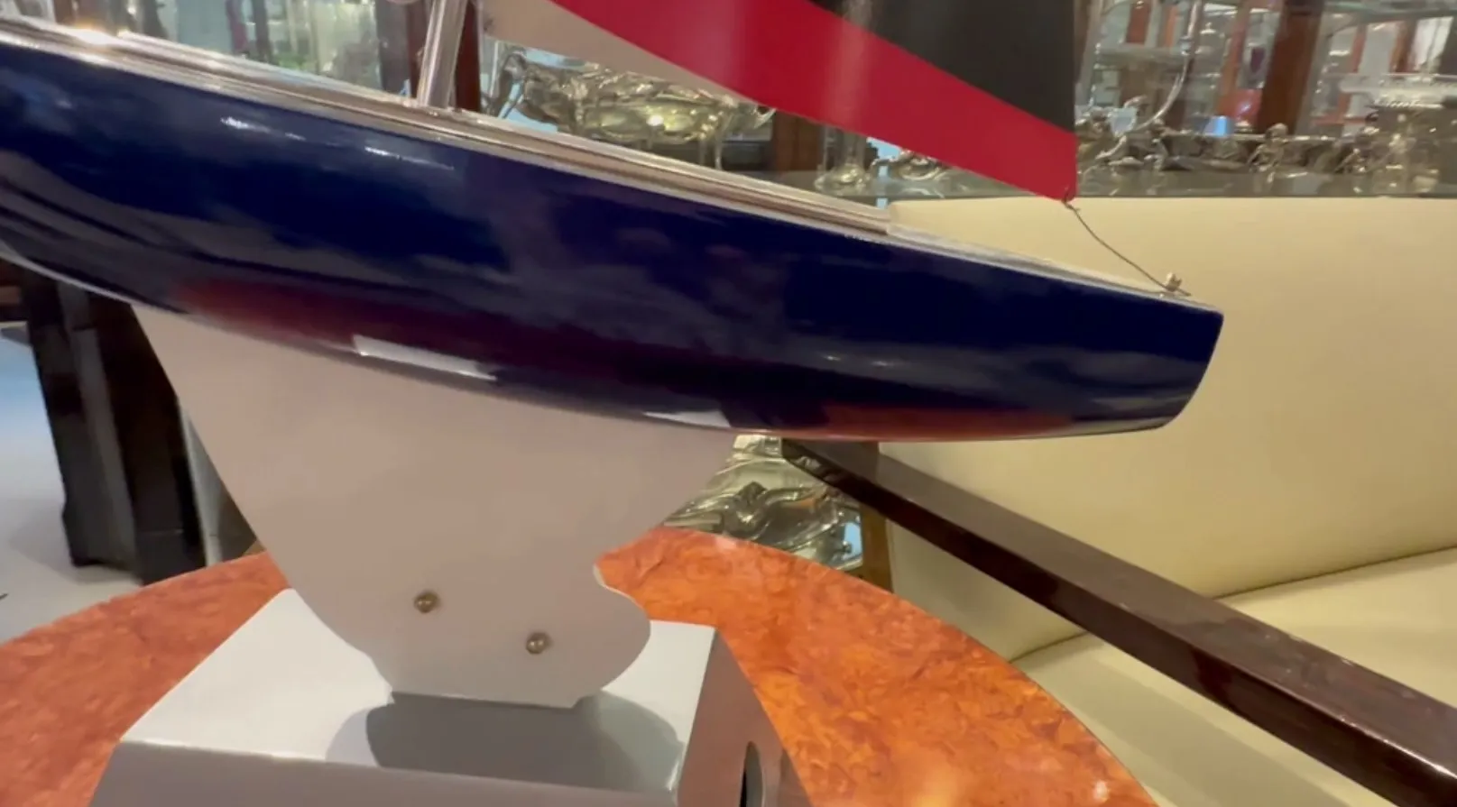 Barco do designer exposto em vitrine, azul e vermelho.