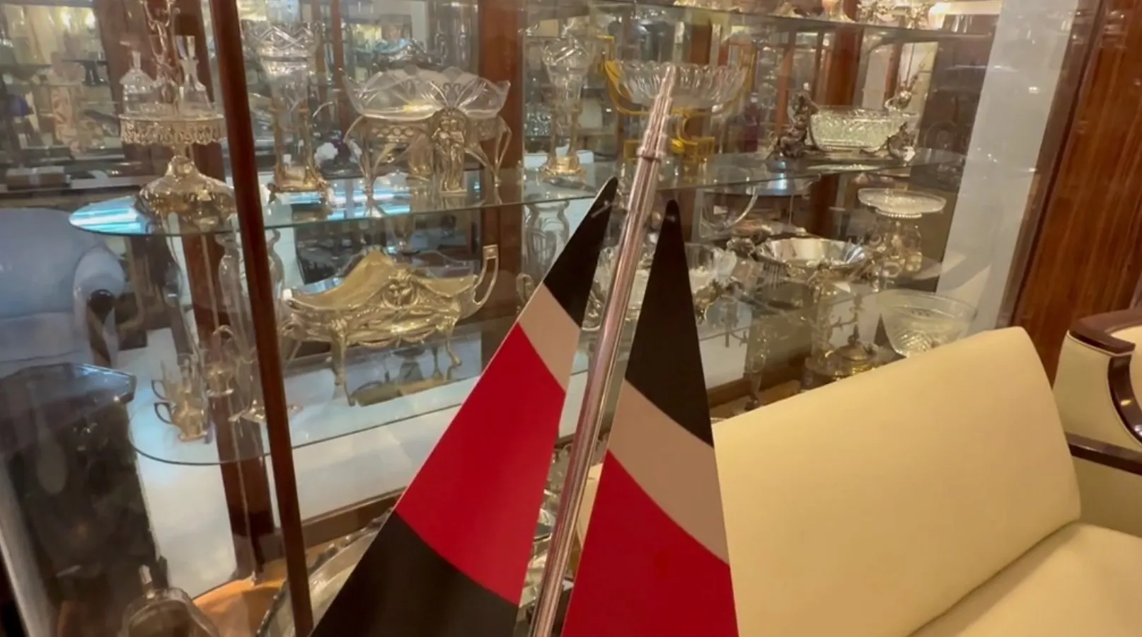 Bateau ancien du designer avec des drapeaux en exposition, entouré d'antiquités.